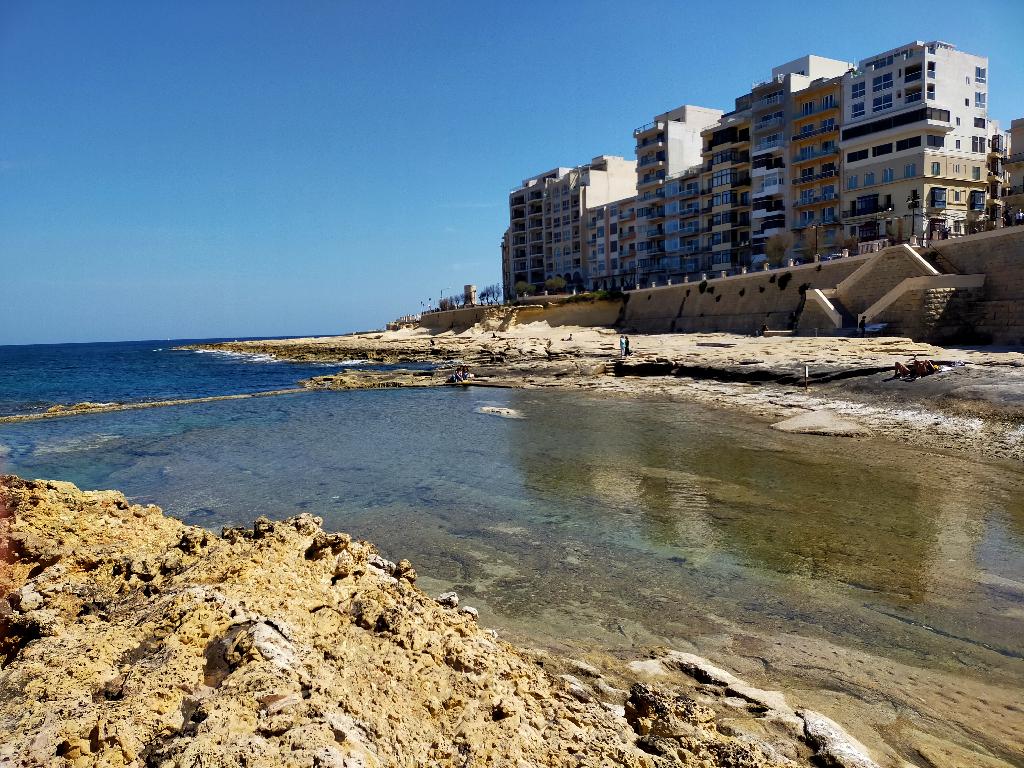 Kamienista plaża w Sliemie i bloki nad morzem