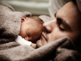 Ojciec i dziecko śpią przytuleni